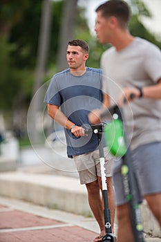 Young men riding rental scooters Las Olas Riverwalk