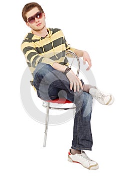 Young men sit on chair cross one's legs