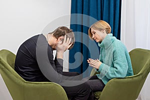 A young man sits in a chair and talks to a psychologist. Healthcare concept of professional psychologist doctor consulting in