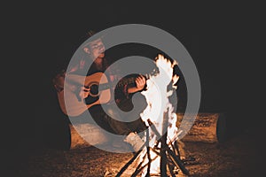 Young men. sitting around camp fire