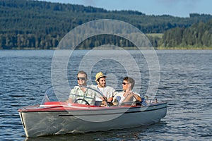 Young men sitting in motorboat scenic landscape