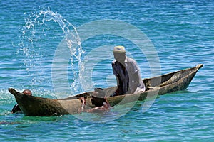 Young men splashing the water from the boatin Madagascar