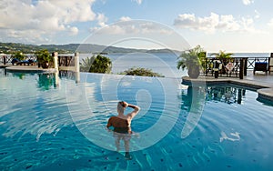 Young men in swim short at Saint Lucia Caribean, men at infinity pool during sunset