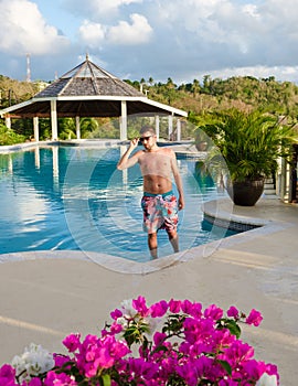 Young men in swim short at Saint Lucia Caribean, men at infinity pool during sunset