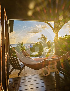 Young men in swim short sunbathing in hammock at Saint Lucia Caribean,