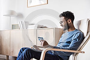 Young men using digital tablet with credit card. Businessman or entrepreneur working at home.