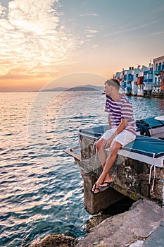 Young men on vacation Greece, Mykonos Greece, Little Venice Mykonos Greece, sunset at ocean fron at Mykonos town