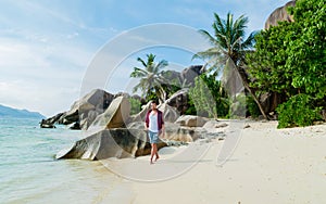 Young men walking at a white tropical beach Anse Source d'Argent beach La Digue Seychelles Islands