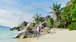 Young men walking at a white tropical beach Anse Source d'Argent beach La Digue Seychelles Islands