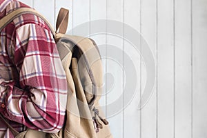 Young men wear red gingham shirt with backpack vintage style on white wood background
