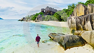 Young men at a white tropical beach Anse Source d'Argent beach La Digue Seychelles Islands