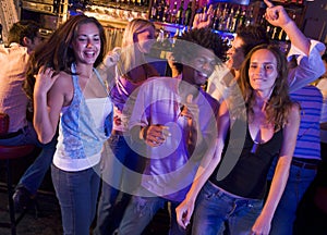 Young men and women dancing in a nightclub photo