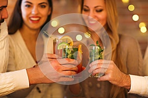 Young men and women drinking cocktail at party