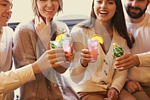 Young men and women drinking cocktail at party