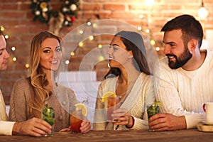 Young men and women drinking cocktail at party