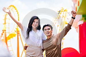 Young men and women playing at the amusement park. A couple in theme park