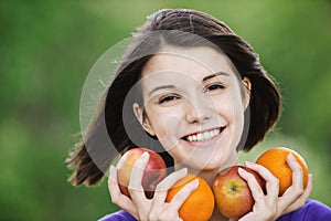 Young merry woman holding fruits