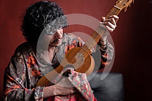 A young Mexican musician is cleaning his jarana guitar