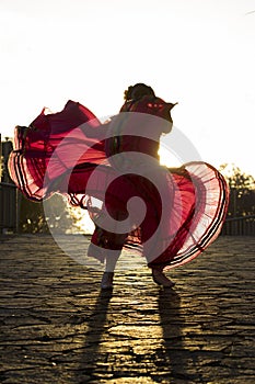 A young mexican woman dancing folkloric dance photo