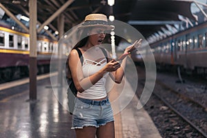 Young Mexican woman holding phone on train platform