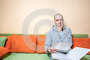 Young or middle age sick man in the casual clothes reading medical results on the papers from his doctor and realize that he have