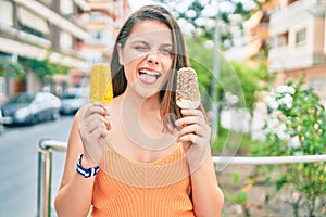 Young middle east girl bitting tongue and winking holding ice cream at the city