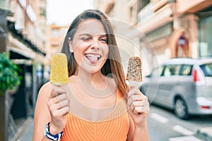 Young middle east girl bitting tongue and winking holding ice cream at the city