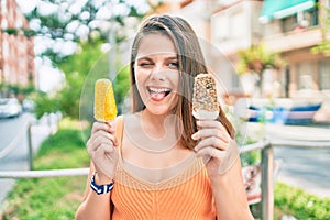 Young middle east girl bitting tongue and winking holding ice cream at the city