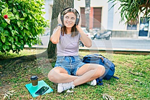 Young middle east student girl smiling happy using headphones at the university campus