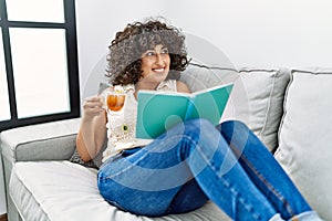 Young middle east woman drinking tea reading book at home