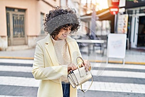 Young middle east woman excutive smiling confident holding handbag at street