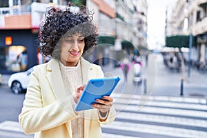 Young middle east woman excutive smiling confident using touchpad at street