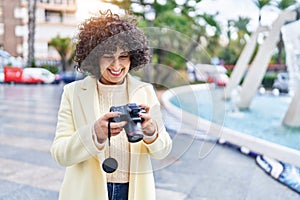 Young middle east woman excutive smiling using professional camera at park