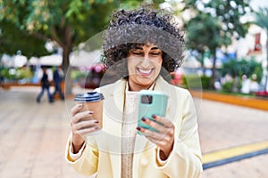 Young middle east woman excutive using smartphone drinking coffee at park