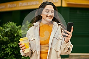 Young middle east woman using smartphone drinking coffee at the city