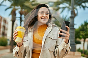 Young middle east woman using smartphone drinking coffee at the city