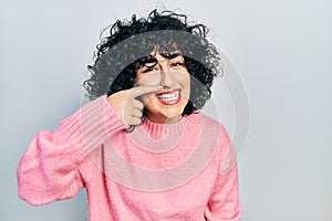 Young middle east woman wearing casual clothes pointing with hand finger to face and nose, smiling cheerful