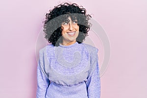 Young middle east woman wearing casual clothes smiling looking to the side and staring away thinking