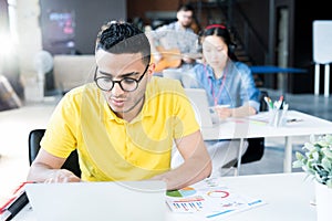 Young Middle Eastern Man Using Laptop in Office