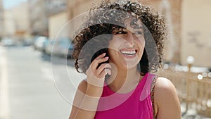 Young middle eastern woman smiling confident talking on the smartphone at street