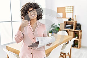 Young middle eastern woman wearing business style at office doing happy thumbs up gesture with hand