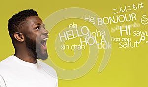 Young millennial afro man saying hello in many languages photo