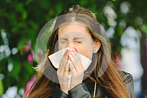 Young millennial sick woman sneeze holding tissue handkerchief and blowing wiping her running nose, concept seasonal allergy