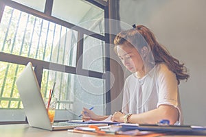 Young millennial working with laptop and paper document