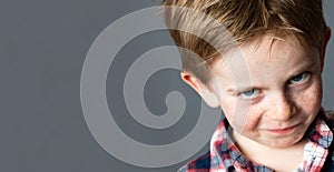 Young mischievous child teasing with grumbling look for joke