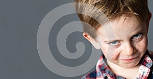 Young mischievous child teasing with grumbling look for joke photo