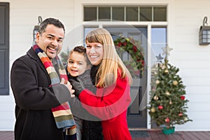 Young Mixed Family On Front Porch of House with Christmas Decorations