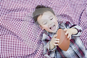 Young Mixed Race Boy Playing with Football on Picnic Blanket