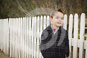 Young Mixed Race Boy Waiting For School Bus Along Fence Outside