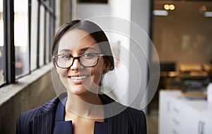 Young mixed race businesswoman wearing glasses, close up